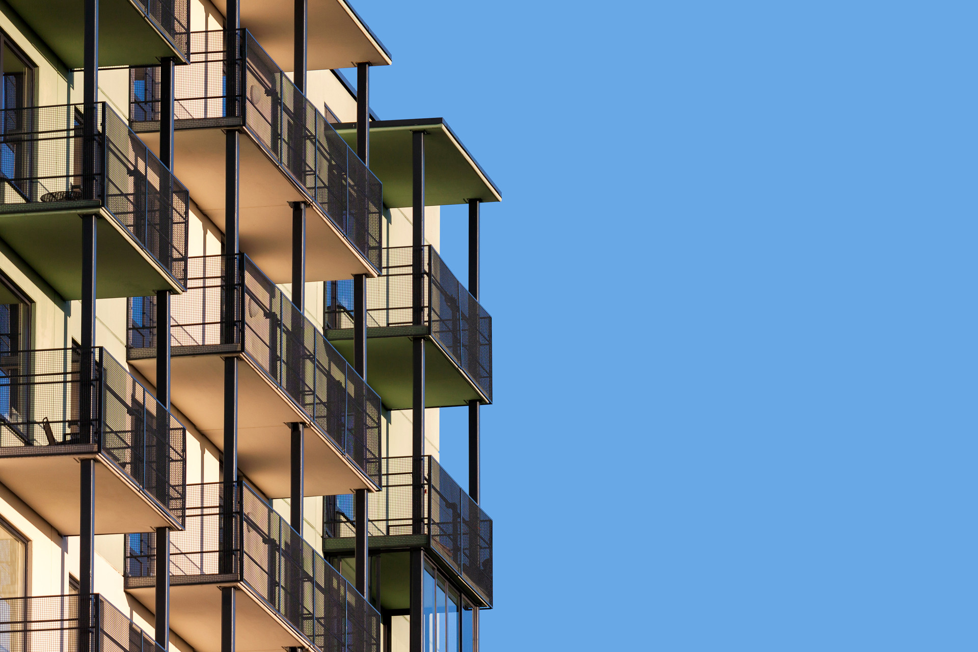 Modern affordable housing building with balconies against a blue sky